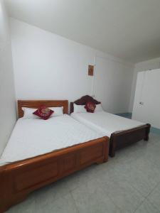 1 dormitorio con 2 camas con almohadas rojas. en Tùy Anh Hostel, en Mù Cang Chải
