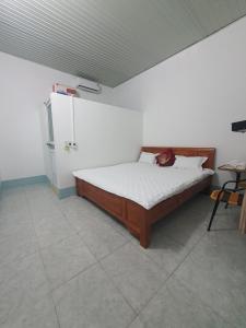 1 dormitorio con 1 cama y nevera en Tùy Anh Hostel, en Mù Cang Chải