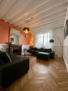 a living room with black couches and a fireplace at *Belle Epoque* residence between Sologne and Berry in Mennetou-sur-Cher