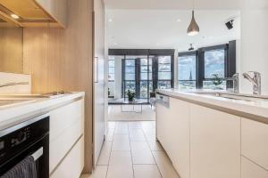 a kitchen with white cabinets and a large sink at Spacious 2 bedroom apartment with Free parking-00189 in Melbourne