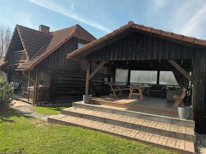 Cabaña con terraza de madera y mesa de picnic en Prystovų sodyba en Prystovai