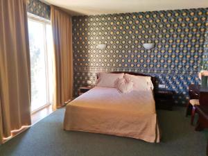 1 dormitorio con cama y pared azul en Twins Palace ApartHotel, en Saints Constantine and Helena