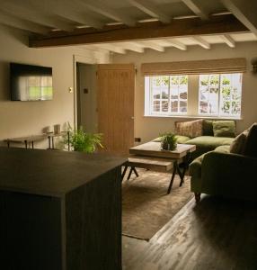 Akasha Spa Retreat Cottage في Welton: غرفة معيشة مع أريكة وطاولة