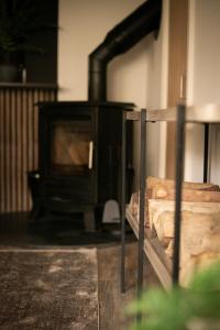 Akasha Spa Retreat Cottage في Welton: موقد خشبي في غرفة بها خشب
