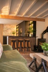 un soggiorno con bar e sgabelli di Akasha Spa Retreat Cottage a Welton