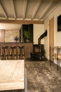 un soggiorno con stufa a legna e sgabelli di Akasha Spa Retreat Cottage a Welton Altre 80 foto