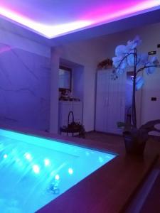 a swimming pool in a room with purple lights at A Trecastagni - Etna Home in Trecastagni