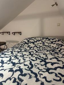 - une chambre dotée d'un lit avec une couverture bleue et blanche dans l'établissement Grand Place Roubaix Appartement Style Loft, à Roubaix
