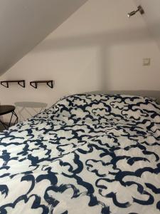 a bedroom with a bed with a blue and white blanket at Grand Place Roubaix Appartement Style Loft in Roubaix