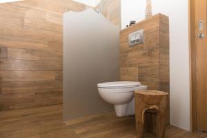 uma casa de banho com um WC e uma parede de madeira em Private cottage, elegance & amazing view em Akureyri