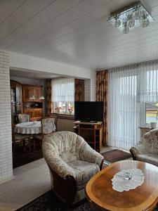 ein Wohnzimmer mit einem Tisch, Stühlen und einem TV in der Unterkunft Ferienwohnung  Monteurwohnung - b63890 in Bremerhaven