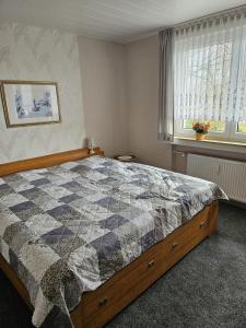 ein Schlafzimmer mit einem Bett mit einer Decke darauf in der Unterkunft Ferienwohnung  Monteurwohnung - b63890 in Bremerhaven