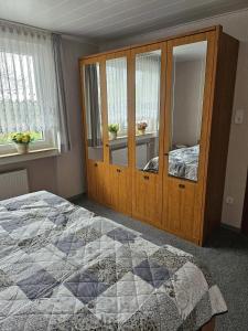 Schlafzimmer mit einem Bett und einem Holzschrank in der Unterkunft Ferienwohnung  Monteurwohnung - b63890 in Bremerhaven
