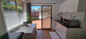 a kitchen with a view of a door to a patio at Guest Studio in Campbelltown 