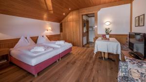 a hotel room with a bed and a table at Residence Tolderhof - Olang in Valdaora