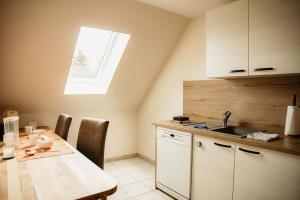 a kitchen with a table with a sink and a window at Ferienwohnung Hohner Seeblick in Hohn +16 photos