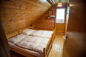 une chambre avec un lit dans une cabane en bois dans l'établissement Holiday House Damjana (Hiška Damjana), Ukanc, Bohinjsko jezero, à Bohinj