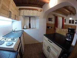 une petite cuisine avec une cuisinière et un évier dans l'établissement Holiday House Damjana (Hiška Damjana), Ukanc, Bohinjsko jezero, à Bohinj 13 autres photos