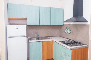 a kitchen with blue cabinets and a sink and a refrigerator at Residence Daniele in Bellaria-Igea Marina