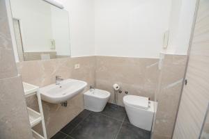 W łazience znajduje się umywalka, toaleta i lustro. w obiekcie Residence Daniele w mieście Bellaria-Igea Marina