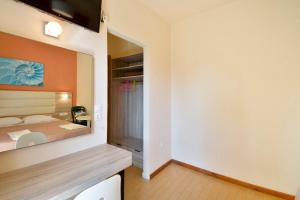 a bedroom with a bed and a large mirror at Hotel Orpheus in Gouvia