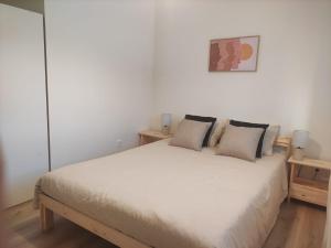 a bedroom with a white bed with two pillows at Casa da Quinta T1 in Mafra