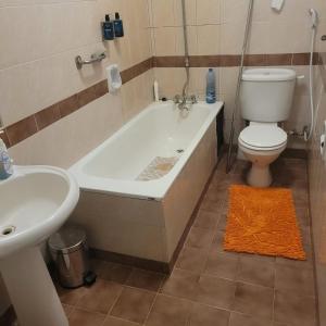 a bathroom with a tub and a toilet and a sink at MOONLIGHT HOMES EAST CHURCH ROAD Westlands in Nairobi