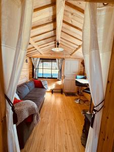 a living room with a couch in a tiny house at The Hideout Log Cabin- 2km to Klarälvsbanan and swimming area in Munkfors