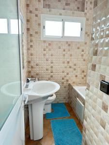 uma casa de banho com um lavatório, um WC e uma banheira em Belyounech pied dans l'eau appartement 2 chambres em Tétouan