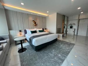 um quarto grande com uma cama grande e um sofá em ARNI Skye Hotel em Bangkok