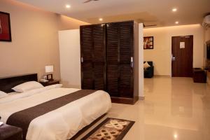 a bedroom with a large bed and a large window at Oak House in Dimāpur