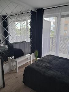 a bedroom with a bed and a large window at Apartament Diament 1 - Jezioro Nyskie in Nysa