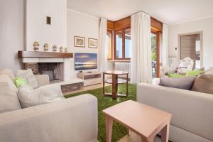 a living room with white furniture and a fireplace at Ca' Le Terrazze With Pool in Garda