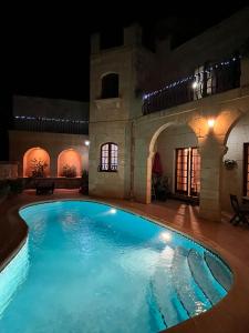 a swimming pool in a building at night at Sant Antnin B&B in Munxar