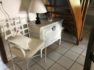 a chair and a lamp next to a table and stairs at DOMAINE du MOULIN in Saint-Avold