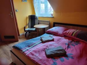 ヤロスワフにあるLwi dworek LDのベッドルーム1室(ベッド1台、椅子、テーブル付)