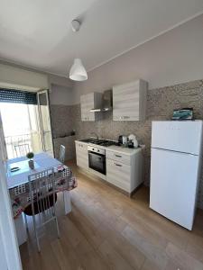 een keuken met een witte koelkast en een tafel bij Panorama House da Tony in Napels
