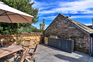 a patio with a table and chairs and a building at Finest Retreats - Potters Cottage in Fowey