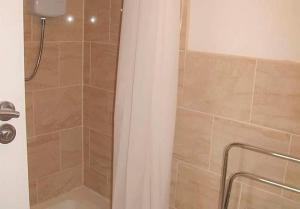 y baño con ducha, cortina de ducha y aseo. en Jubilee House - 4 bedroom central house - bright and spacious, 2 parking spaces, en Filey