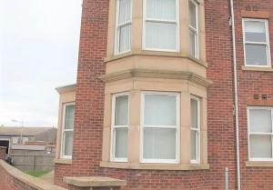 un edificio alto de ladrillo con ventanas blancas en Jubilee House - 4 bedroom central house - bright and spacious, 2 parking spaces, en Filey 7 fotos más