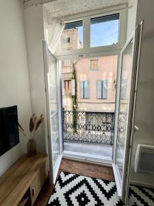 um quarto com uma grande janela com vista para um edifício em Appartement Victor Hugo - balcon em Revel