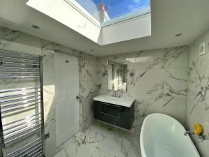 a white bathroom with a sink and a mirror at Finest Retreats - Potters Cottage in Fowey +49 photos