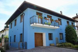 uma casa azul com duas varandas e uma garagem em Casa del Tempo Elsa Tassullo Ospitar em Tassullo