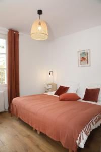 sypialnia z dużym łóżkiem i pomarańczowym kocem w obiekcie Suite Jockey Stable by La Boîte En Plus w mieście Gouvieux