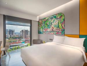 sypialnia z dużym białym łóżkiem i dużym oknem w obiekcie Hotel Mi Rochor w Singapurze