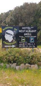 a sign for a hotel restaurant grill in a field at AUBERGE DE CANNEDDA in Sari Solenzara
