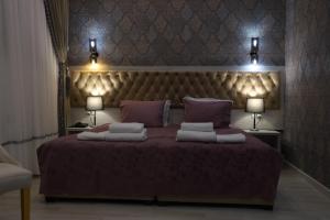 a bedroom with a large bed with two lamps at Renaissance Boutique Hotel in Samarkand