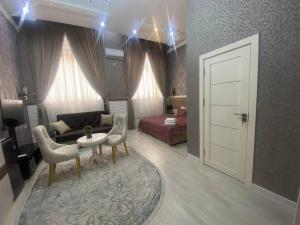 a living room with a bed and a table and a door at Renaissance Boutique Hotel in Samarkand