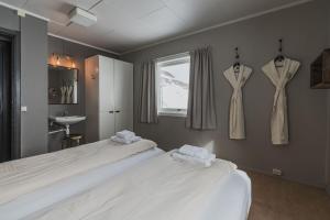 a bedroom with two beds and two dresses hanging on the wall at Coal Miners’ Cabins in Longyearbyen