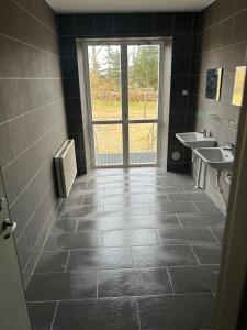 a bathroom with two sinks and a window at Davids Hotell in Alvesta